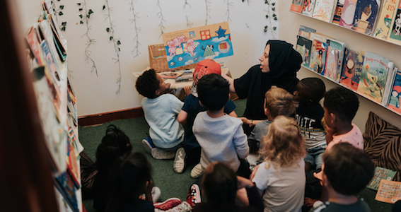 Children gathered around a member of staff ready for story time