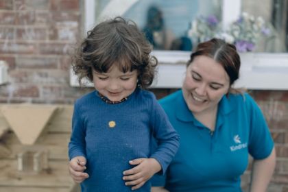 Adult and child smiling outdoors.